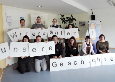 Gruppenbild auf dem die Teilnehmenden des Workshops Buchstaben hochhalten. Es ist zu lesen: Wir erzählen unsere Geschichte! (Foto: ArbeiterKind.de)