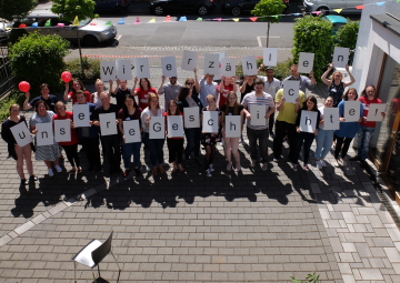 Gruppenfoto unserer Engagierten aus Hessen. Sie haben mehrere Buchstaben in den Händen auf denen steht: "Wir erzählen unsere Geschichte!" 