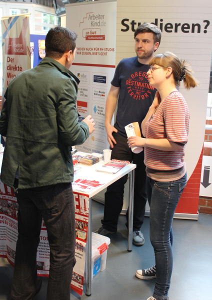 Infostand in Bremen mit zwei Ehrenamtlichen, die einem Ratsuchenden zuhören